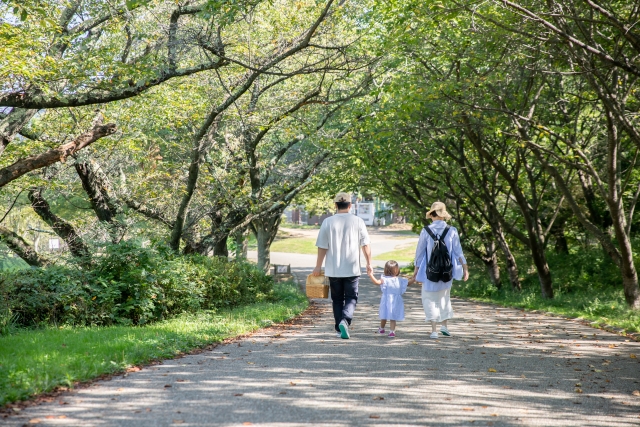 緑のなかを歩く家族、未来の健康を守るイメージ